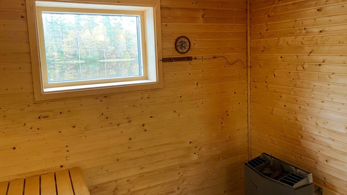Fönster med utsikt mot sjön och bastuagregat inne i sjöbastun.